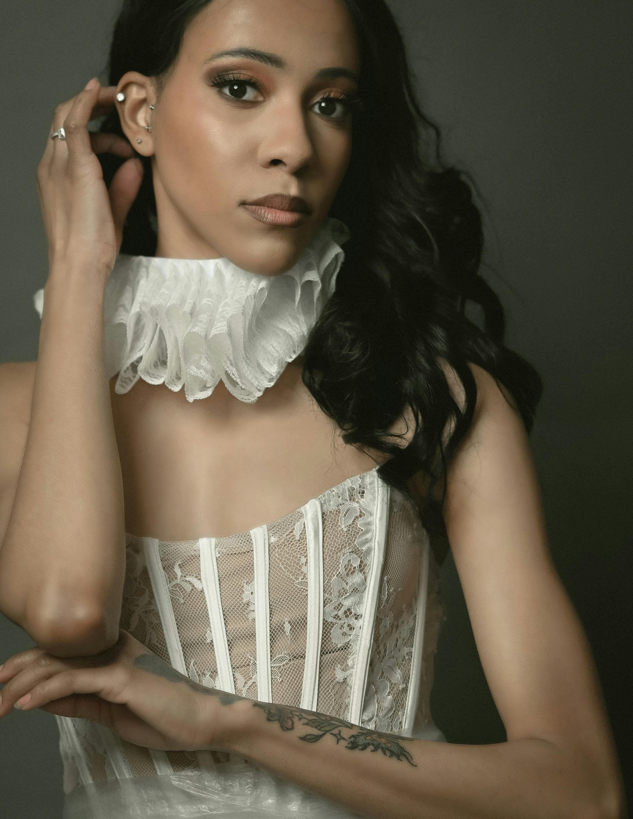 De franc Retrat sofisticat d'una dona amb un vestit de puntes blanques i coll amb volants. Foto d'estoc