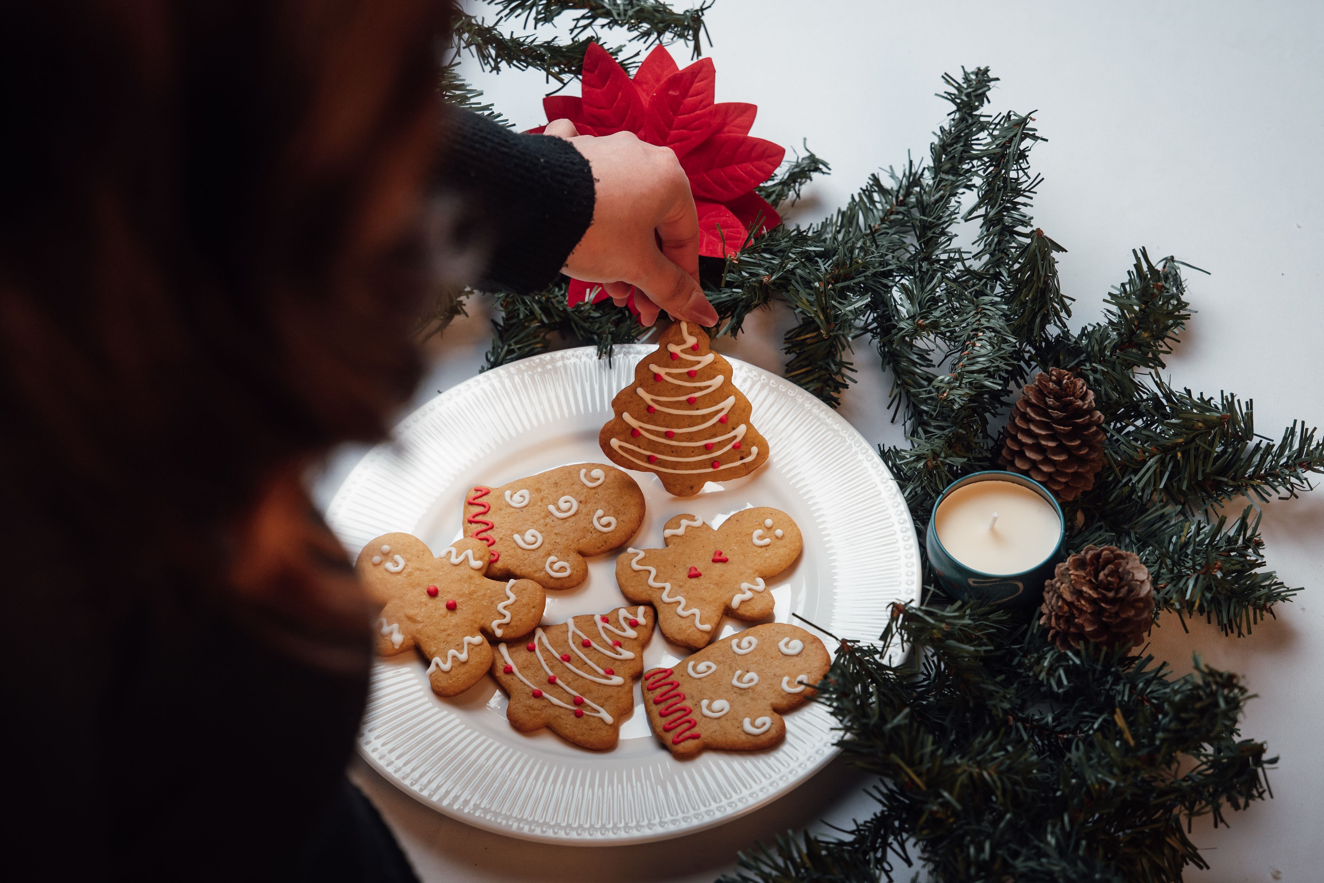 Top view of gingerbread cookies with holiday decorations and greenery.