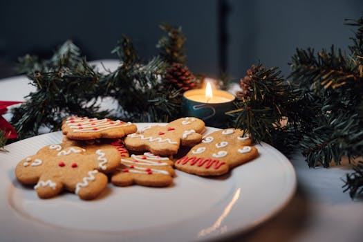 A cozy Christmas scene with decorated gingerbread cookies and candlelight on a table.