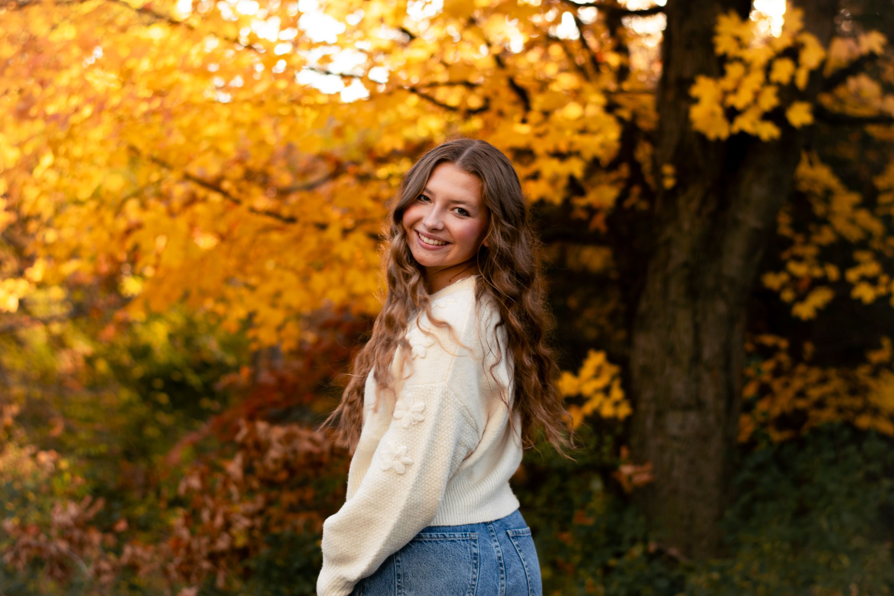 Smiling Young Woman in Autumn Forest Setting · Free Stock Photo