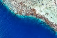 印度尼西亚海岸的空中海景令人惊叹，展现出充满活力的蓝色海水和珊瑚礁