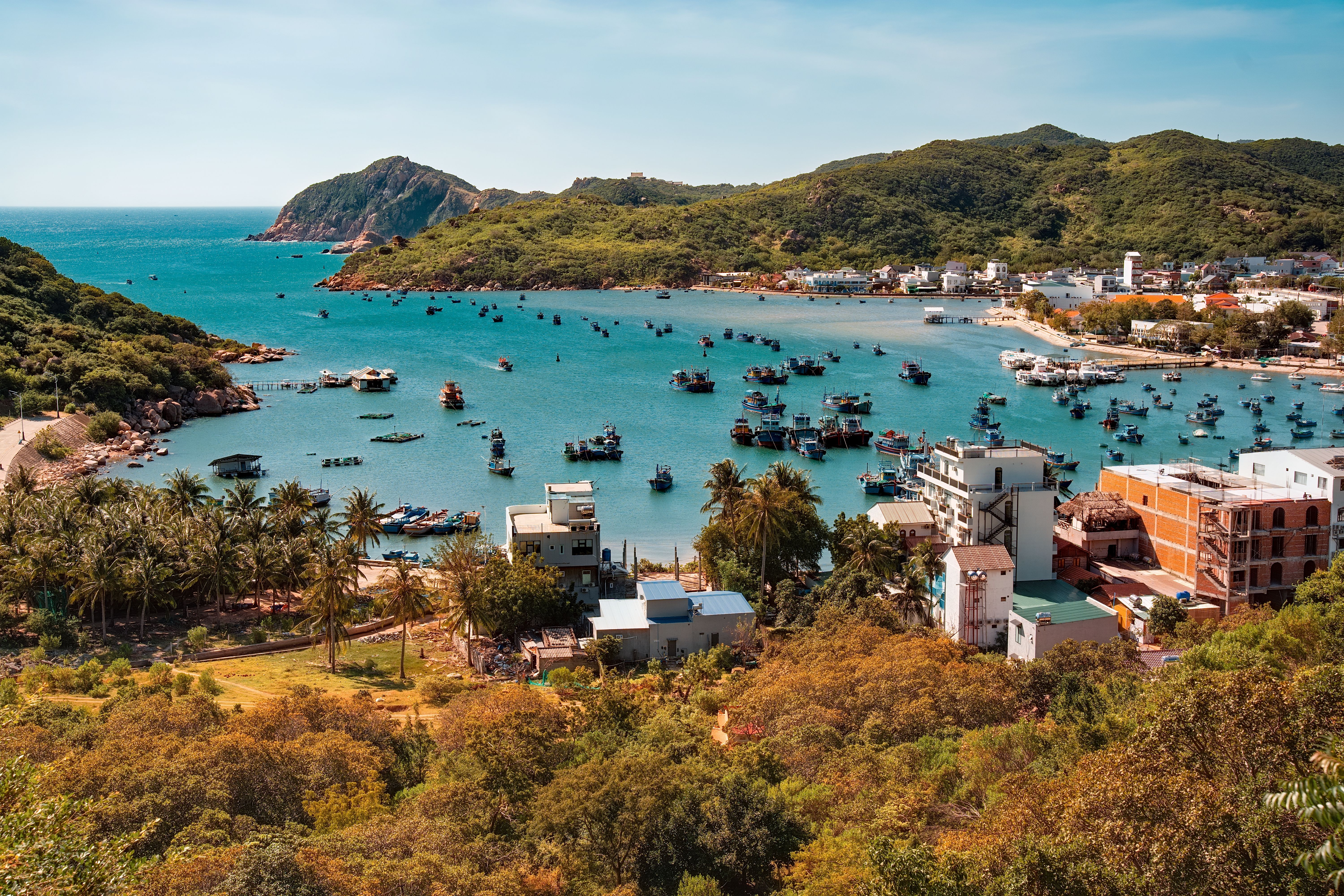 Scenic Coastal Town with Fishing Boats and Hills · Free Stock Photo