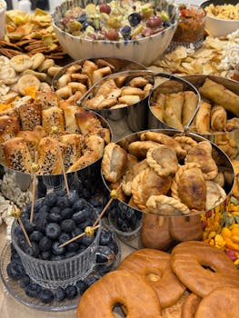 A variety of appetizers including pastries, fruits, and snacks in bowls, perfect for entertaining.