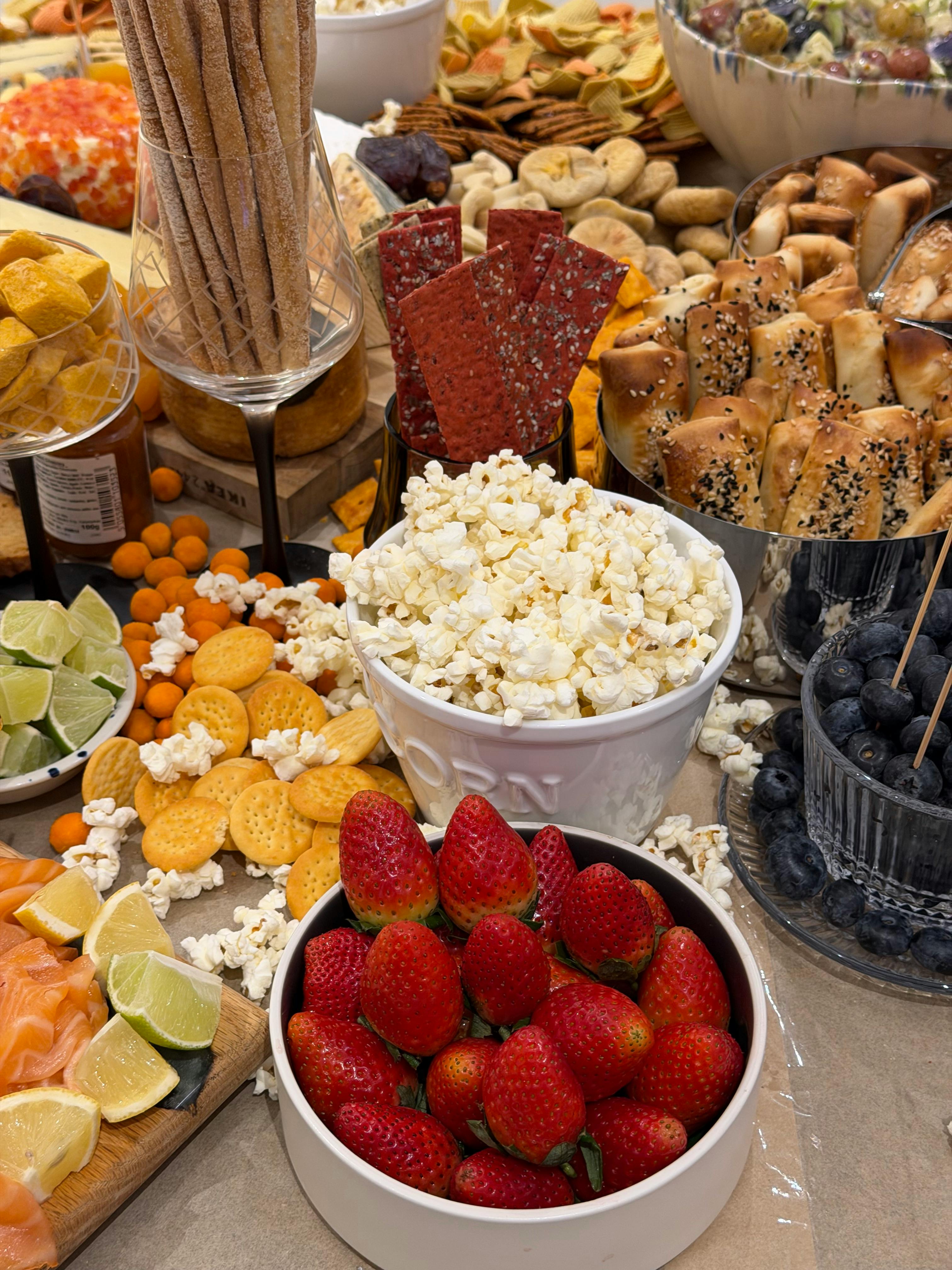 Gratuit Un étalage coloré de collations festives comprenant des fruits, du maïs soufflé et bien plus encore. Photos