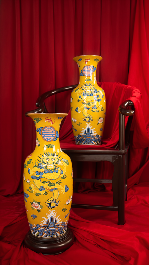 Free Two ornate yellow ceramic vases displayed against a rich red backdrop, showcasing intricate designs. Stock Photo