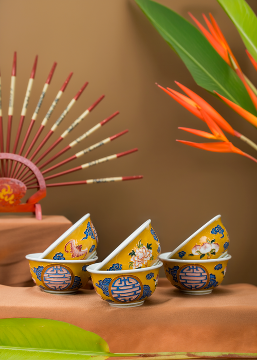Free Colorful ceramic teacups with a Vietnamese fan and orange flowers on display. Stock Photo
