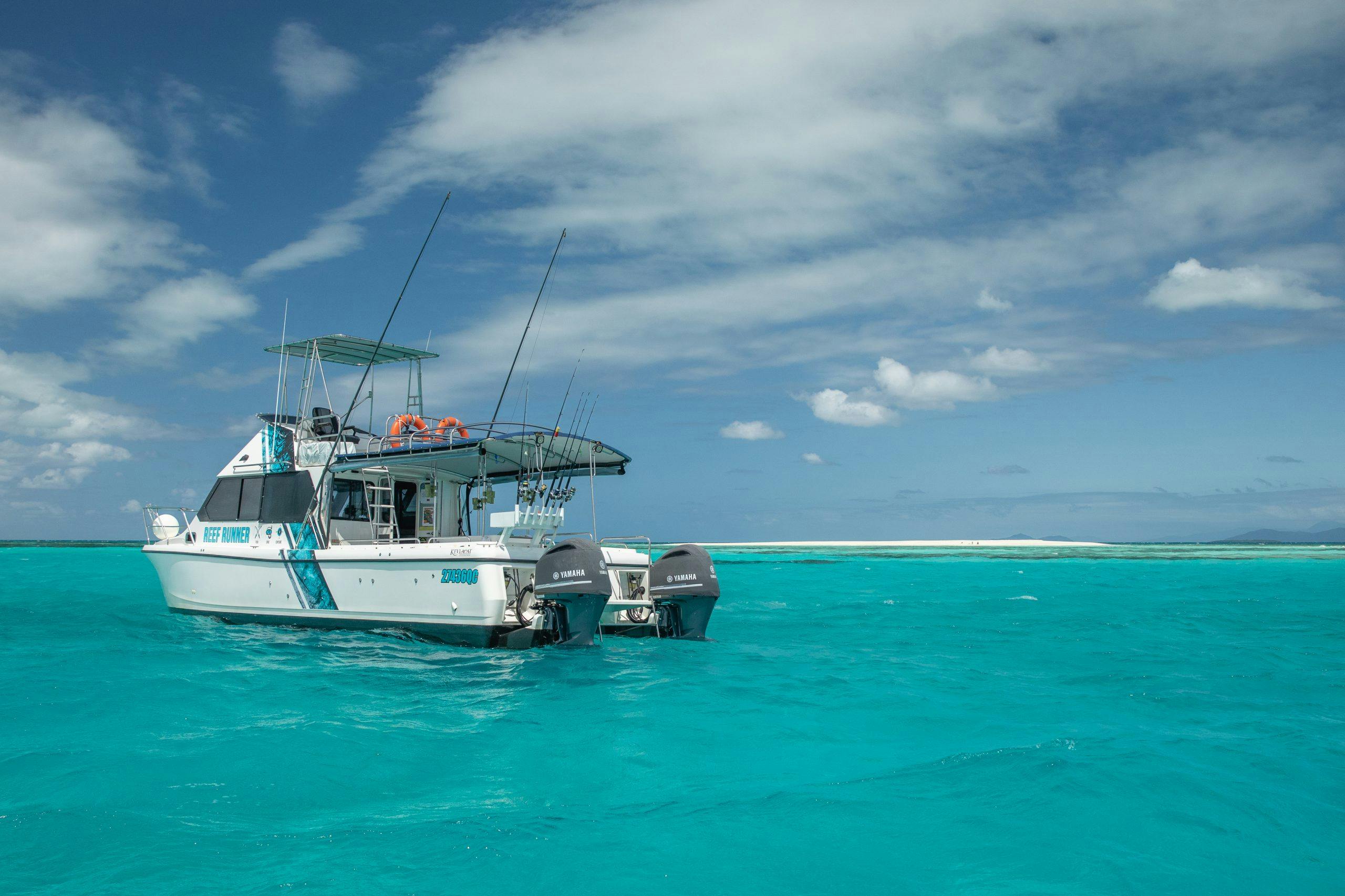 Captivating view of a fishing boat on the vibrant turquoise waters off Edge Hill, Queensland.