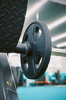 Detailed view of a barbell weight plate in a sleek, modern gym environment.