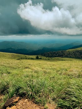 A majestic view of lush green hills and dramatic clouds in Kerala, India.
