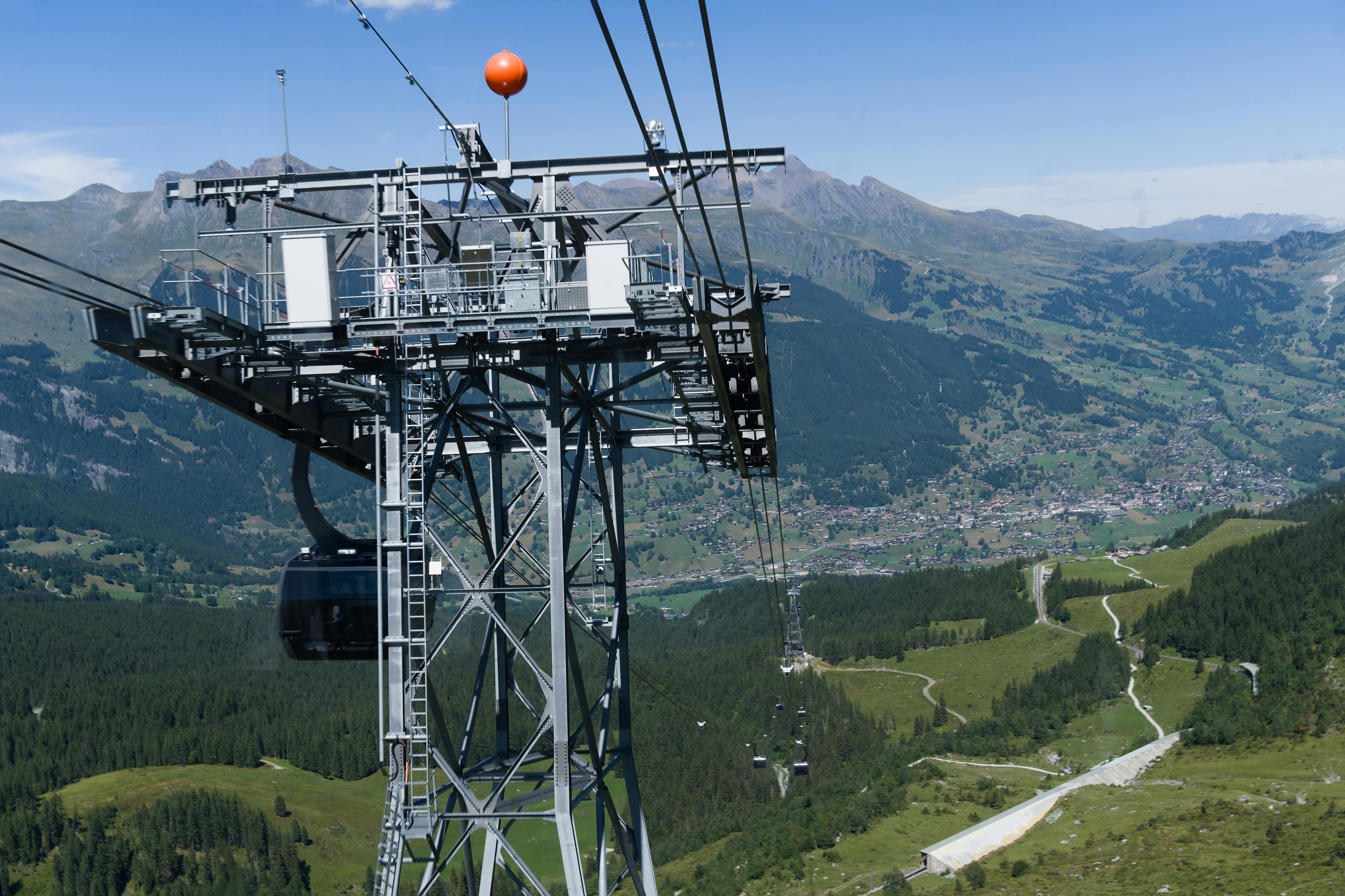 Cable car suspended over Swiss Alps offering breathtaking panoramic views.