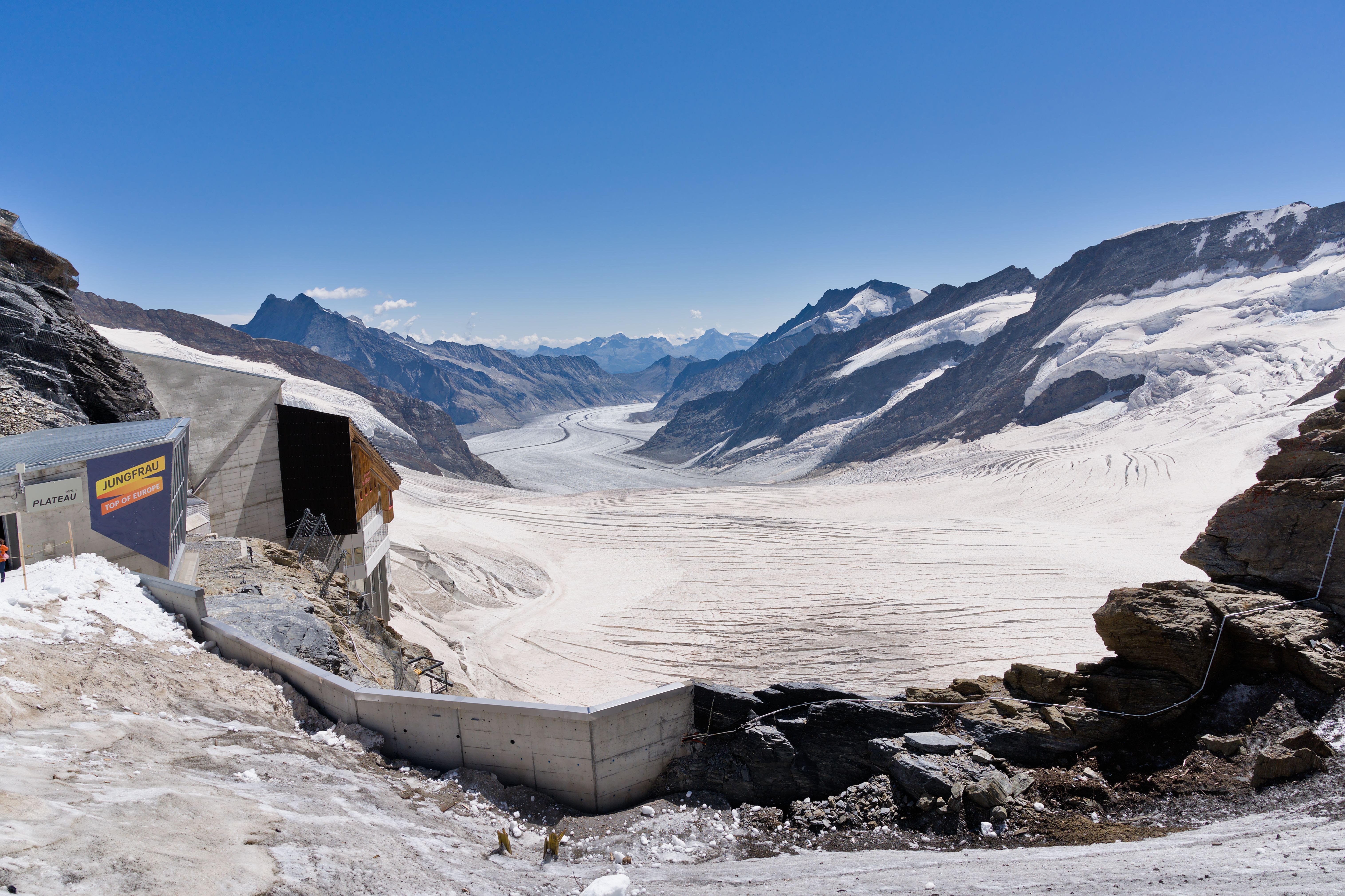 Experience the stunning Aletsch Glacier, nestled in the Swiss Alps, with clear blue skies and majestic mountains.