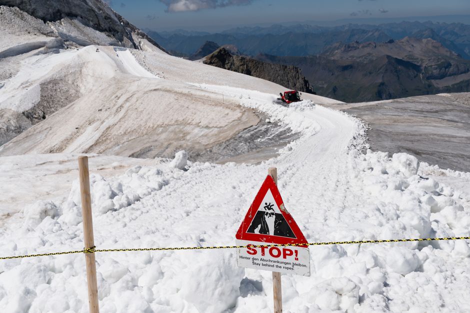 Snow-covered trail with avalanche warning sign on Jungfrau, Switzerland.