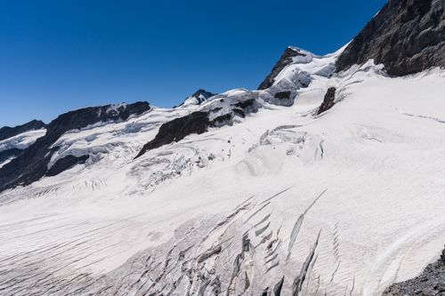 Free Majestic snow-covered mountains and the Aletsch Glacier under a clear blue sky. Stock Photo