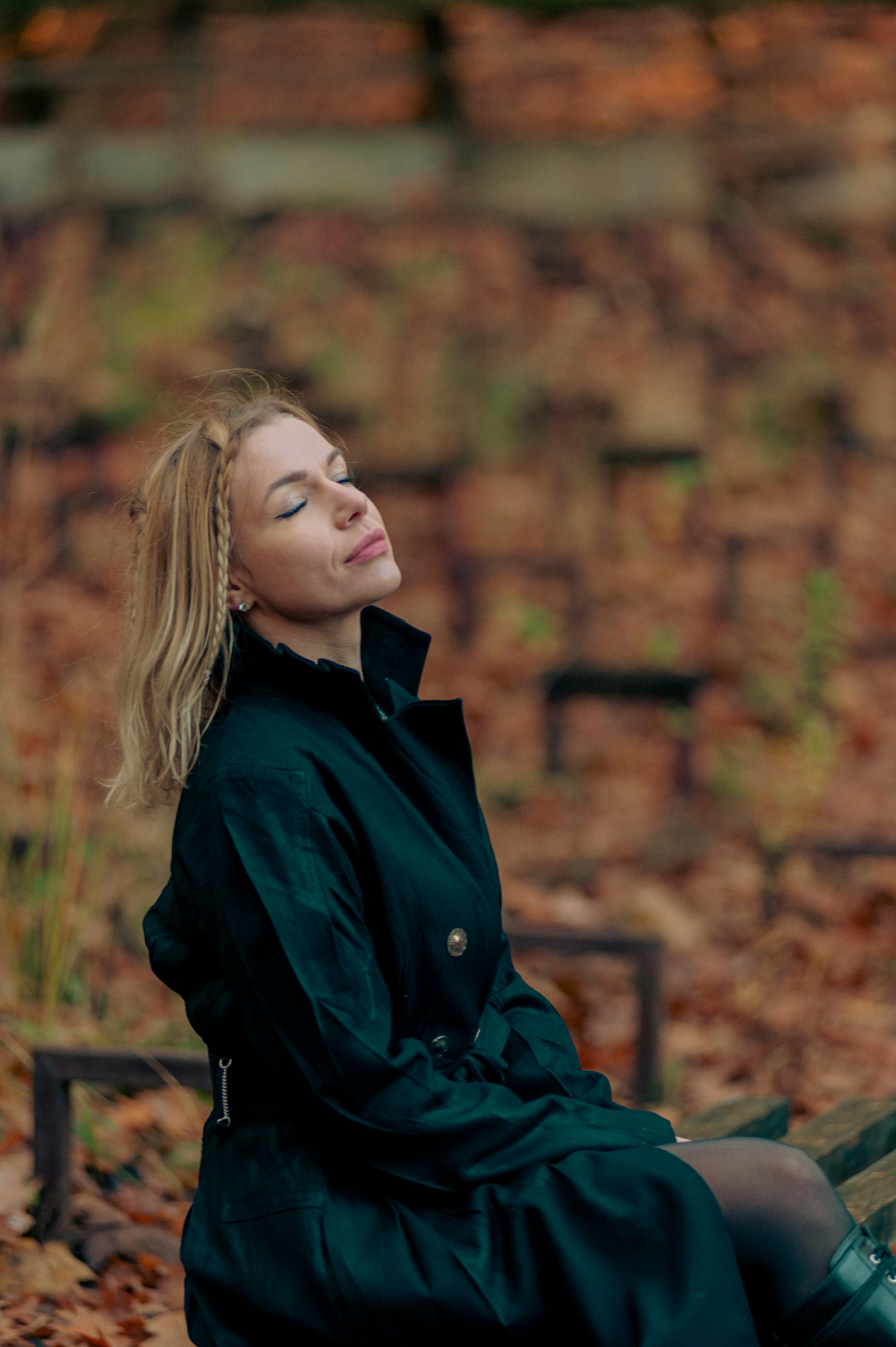 Kostenlos Eine Frau genießt die friedliche Herbstatmosphäre in einem Park in Lemberg, umgeben von leuchtenden Herbstblättern. Stock-Foto
