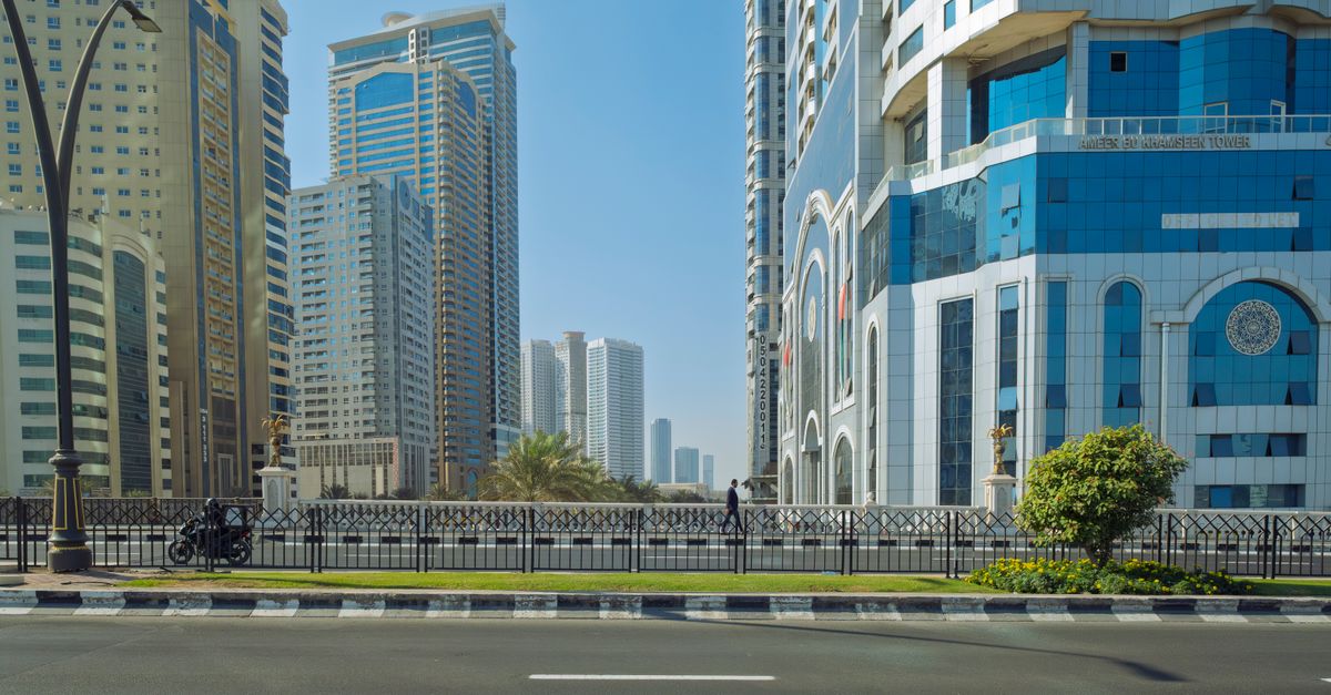 Urban landscape of Sharjah, UAE featuring modern skyscrapers under a clear blue sky.