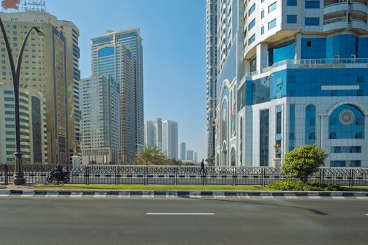Urban landscape of Sharjah, UAE featuring modern skyscrapers under a clear blue sky.