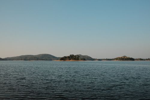 Free A serene view of a lake with small islands and a clear blue sky, capturing nature's tranquility. Stock Photo