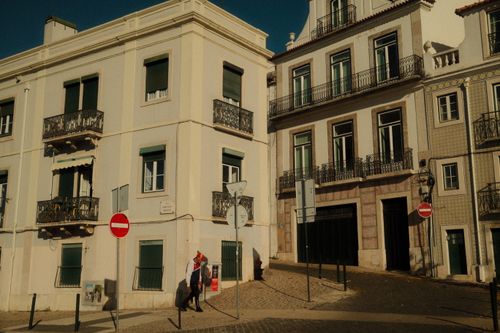 Free Charming sunlit corner of Lisbon, showcasing traditional Portuguese architecture and classic street signs. Stock Photo