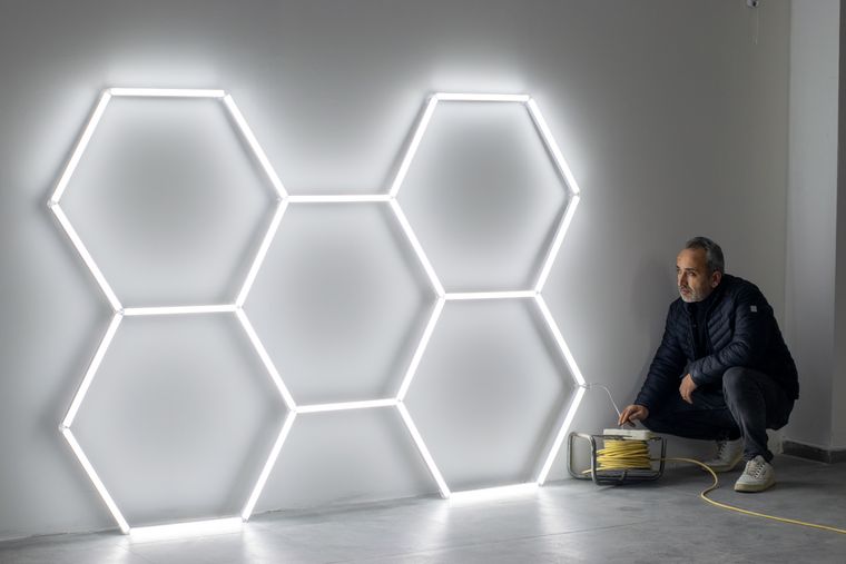Técnico montando luminarias LED en una pared de un local