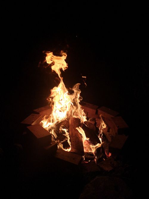 Free A captivating campfire with vivid flames surrounded by bricks in the dark of night. Stock Photo