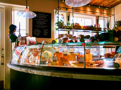 A cozy cheese counter with various cheeses and products at a Houston deli.