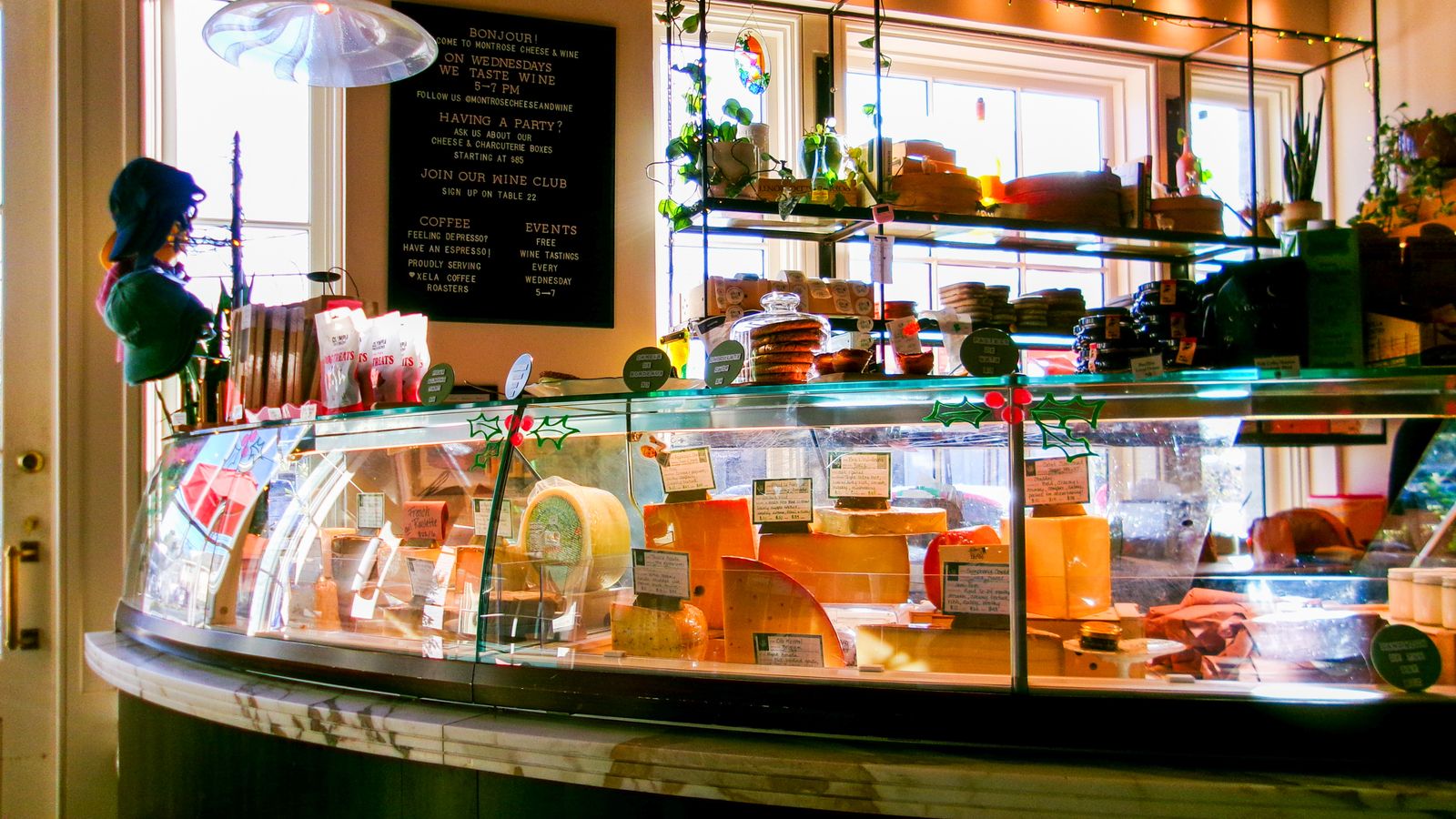 A cozy cheese counter with various cheeses and products at a Houston deli.