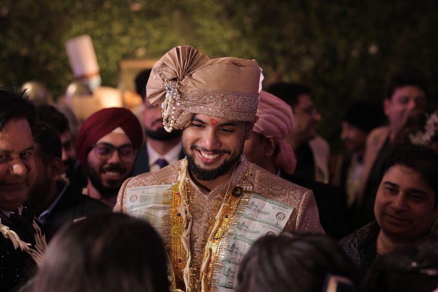 Groom wearing an ivory embroidered sherwani with a matching safa turban