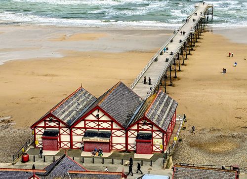 Free A picturesque aerial view of Saltburn-by-the-Sea's Victorian pier and beach scene in England. Stock Photo