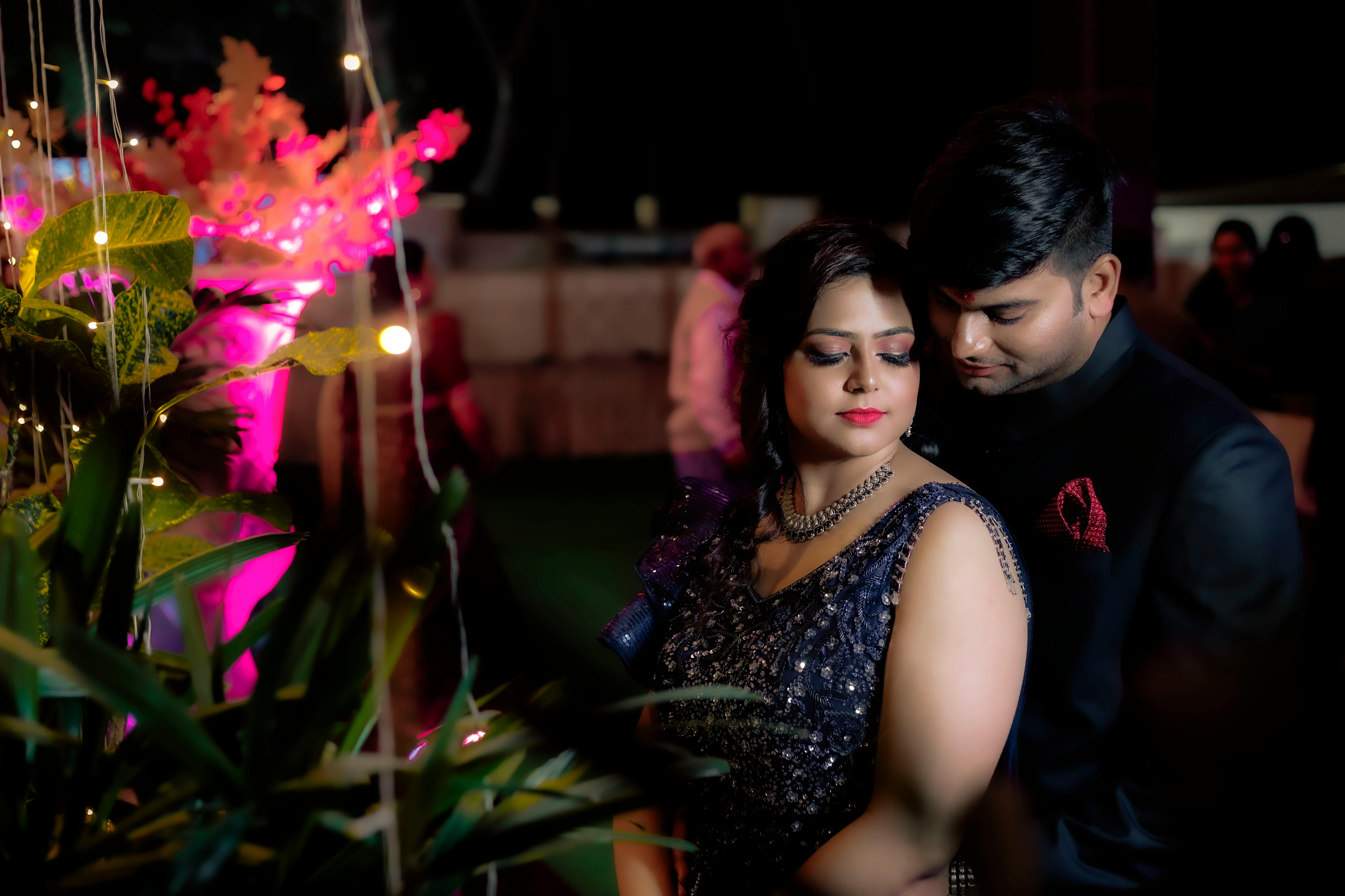 De franc Parella elegant abraçant-se a la nit envoltada de llums i decoració vibrants. Foto d'estoc