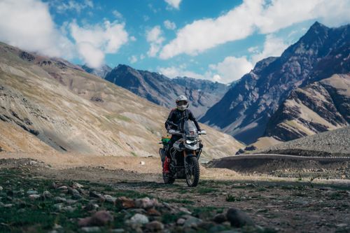 Free Adventure motorcyclist on rugged mountain terrain during daytime exploring scenic views. Stock Photo