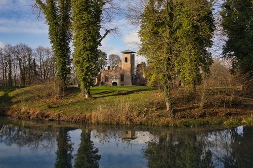 Free Charming historic castle nestled by a calm lake surrounded by lush greenery. Stock Photo