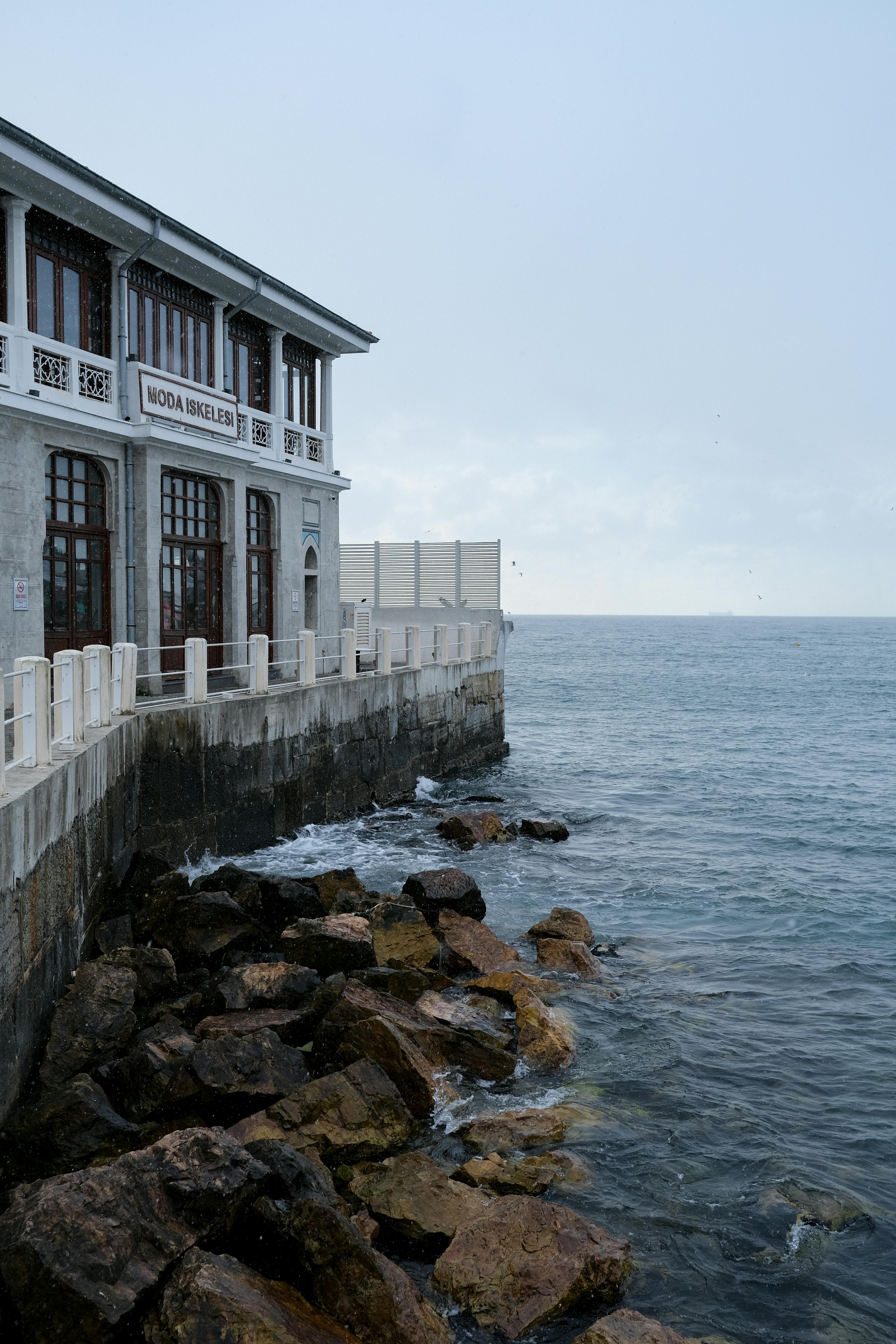Kostenlos Ein malerischer Blick auf ein Gebäude am Meer, umgeben von Felsen und Meereswellen. Stock-Foto