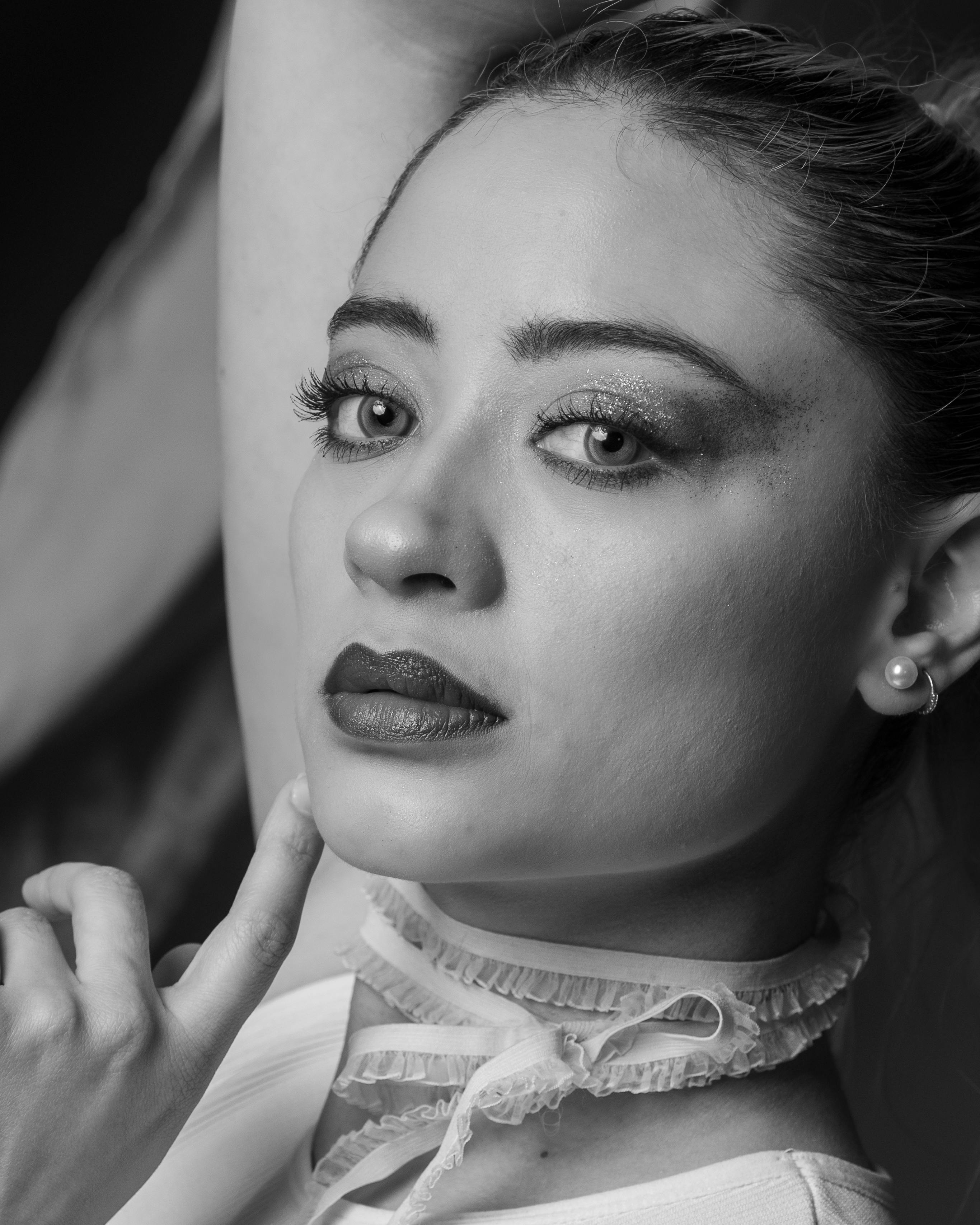 De franc Retrat en blanc i negre impressionant d'una dona amb ulls expressius i vestimenta elegant. Foto d'estoc