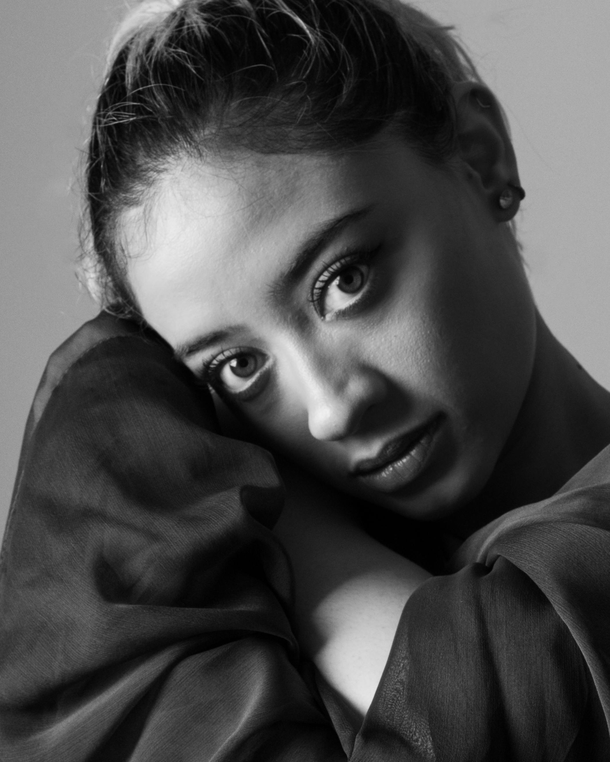 De franc Retrat elegant en blanc i negre d'una dona jove amb ulls expressius i trets delicats. Foto d'estoc