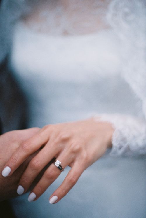 Free Close-up of a bride's hand with elegant wedding rings and white lace dress. Stock Photo