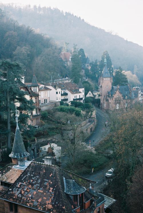 Free Scenic view of a quaint European village with misty hills and historic architecture. Stock Photo