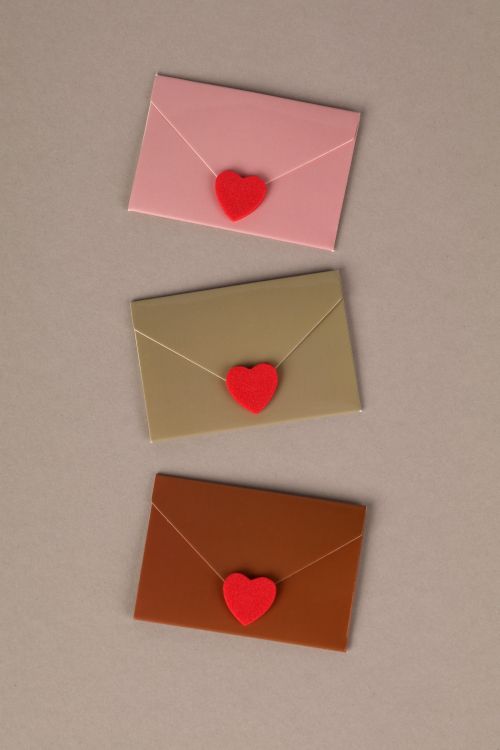 Free Flat lay of three envelopes in pink, beige, and brown with red heart seals, symbolizing love and affection. Stock Photo