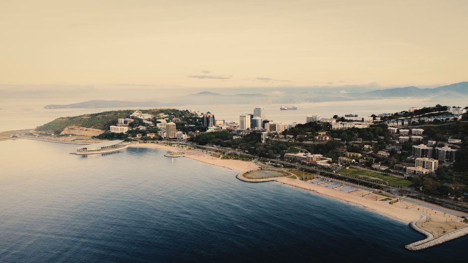 Aerial view of Port Moresby with its scenic coastline and urban landscape at sunrise.