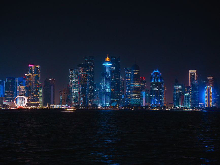 Doha city skyline at night with illuminated metro tracks in Qatar