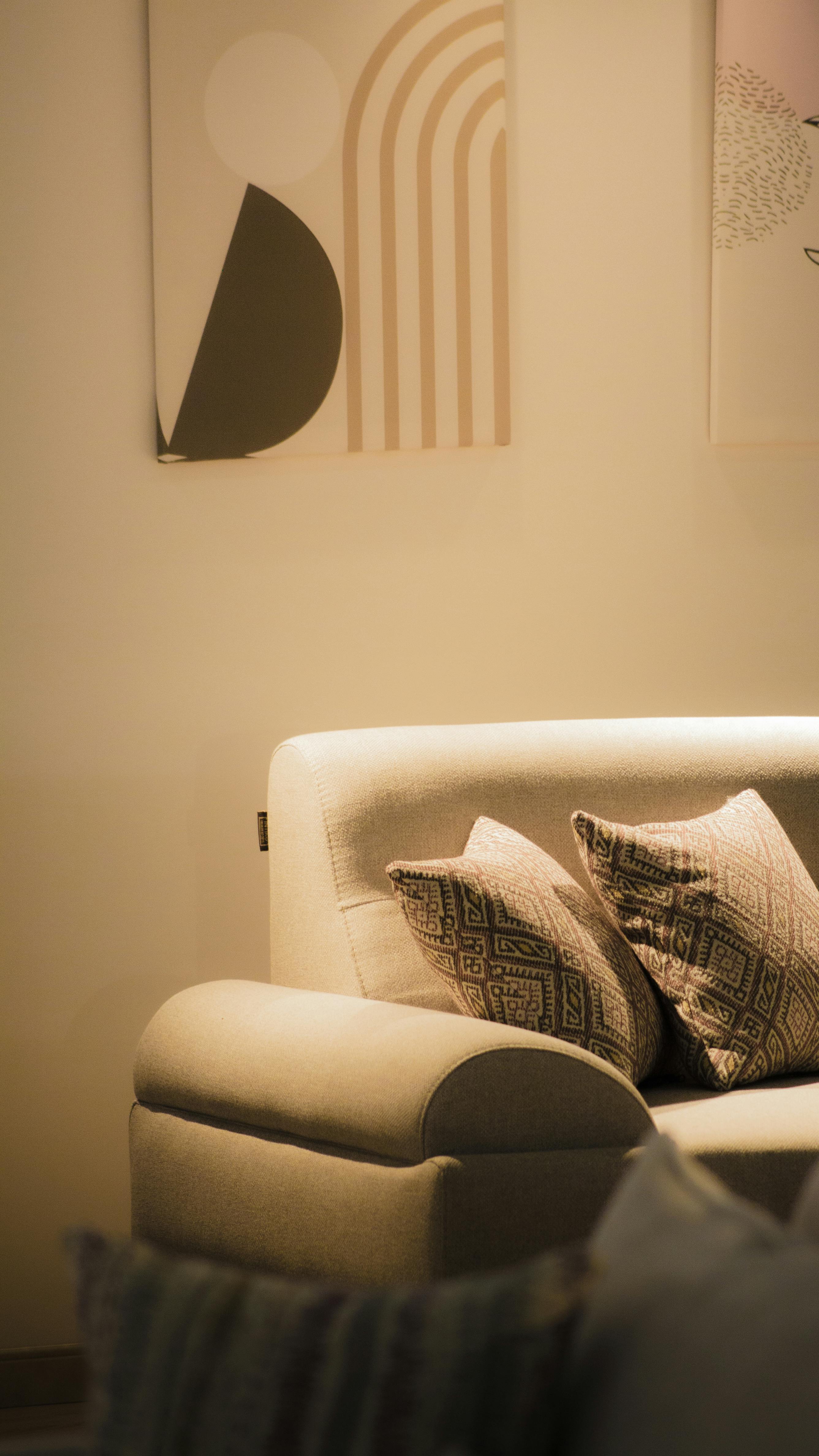 De franc Sofà decorat amb estil, coixins moderns i art abstracte a la paret. Foto d'estoc