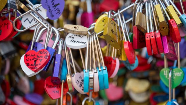 Vibrant heart-shaped love locks attached to a bridge, symbolizing eternal affection and commitment.