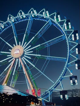 Colorful Ferris wheel glowing against a dark night sky, capturing a festive atmosphere.