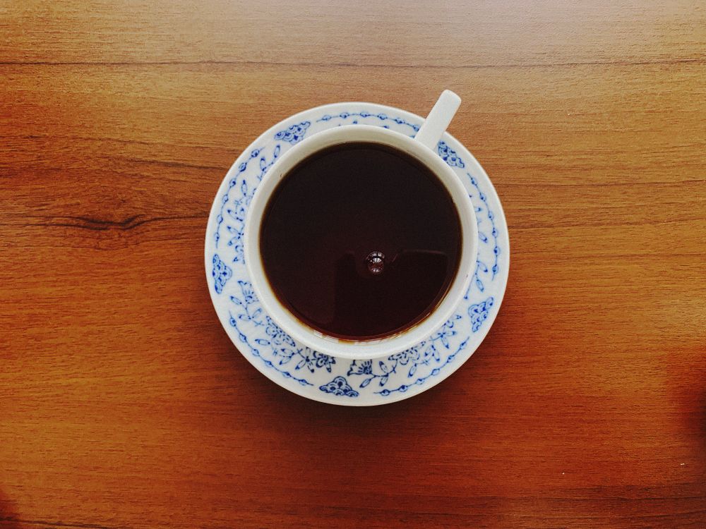 Coffee cup on a wooden table, seen from above — photo by Meryem Uslu on Pexels