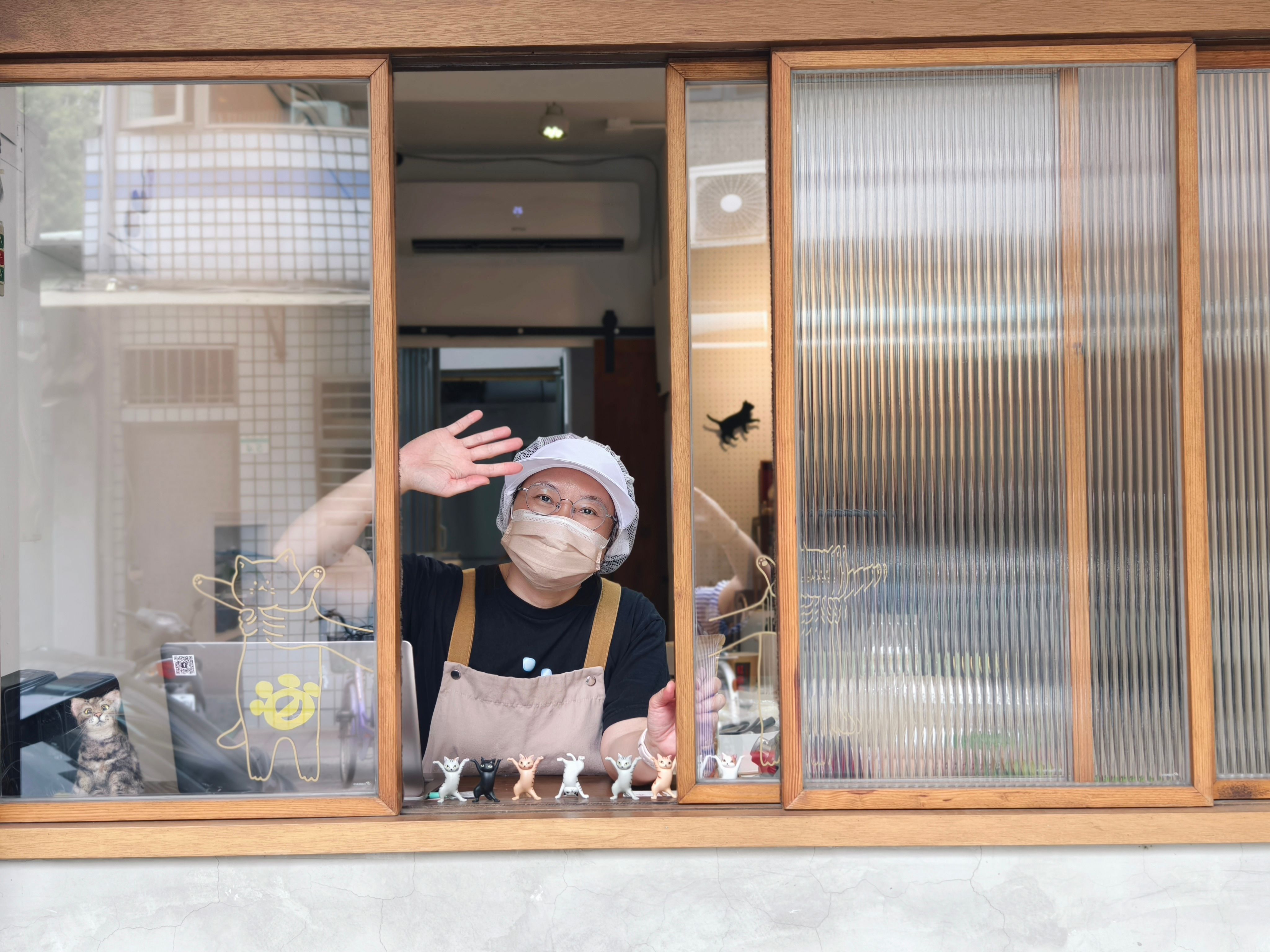 Friendly Baker Waving from Shop Window · Free Stock Photo