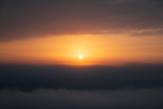 Breathtaking view of a sunrise above clouds, capturing serene beauty and warm tones.