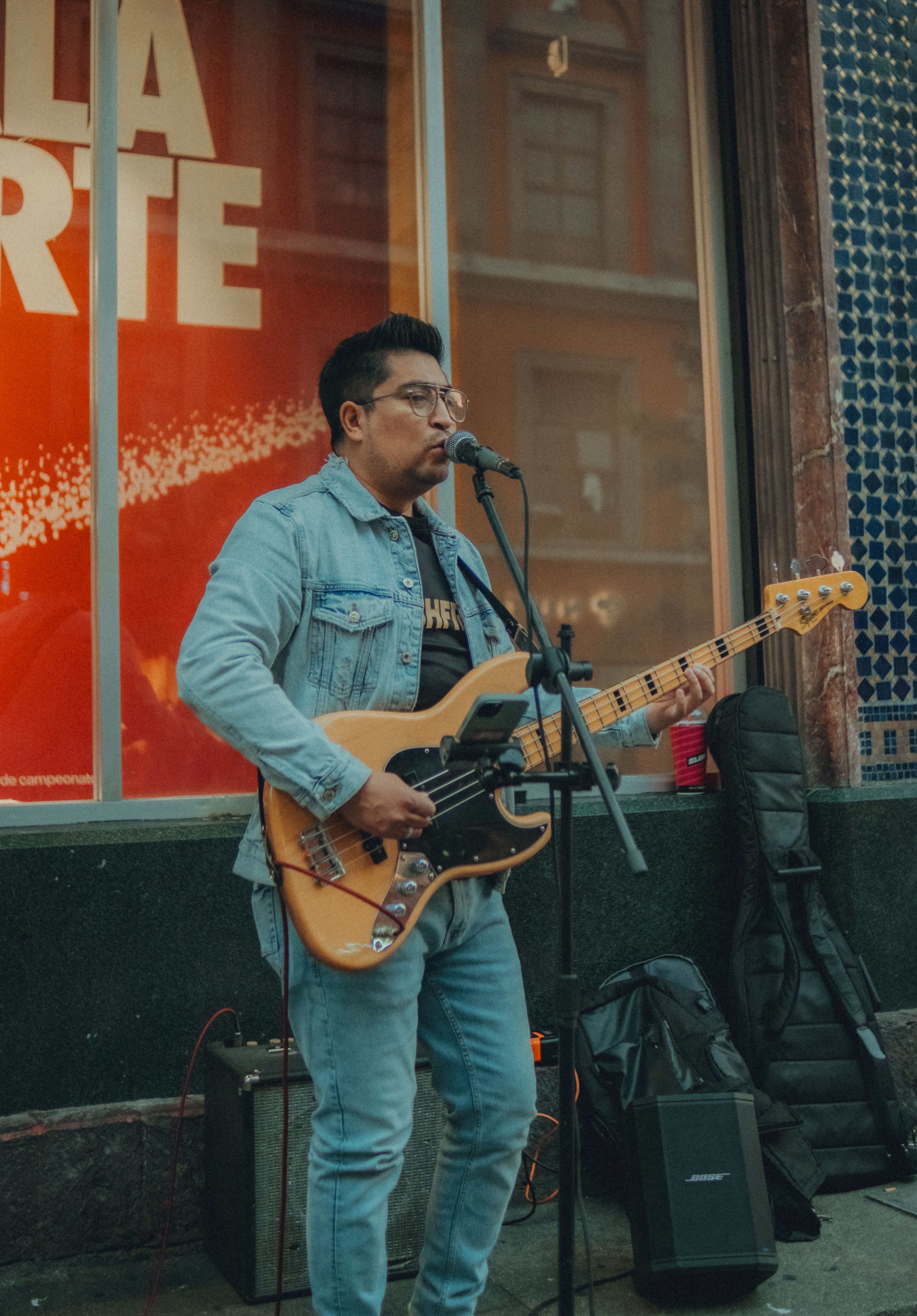 Street musician playing electric guitar and singing in urban setting.