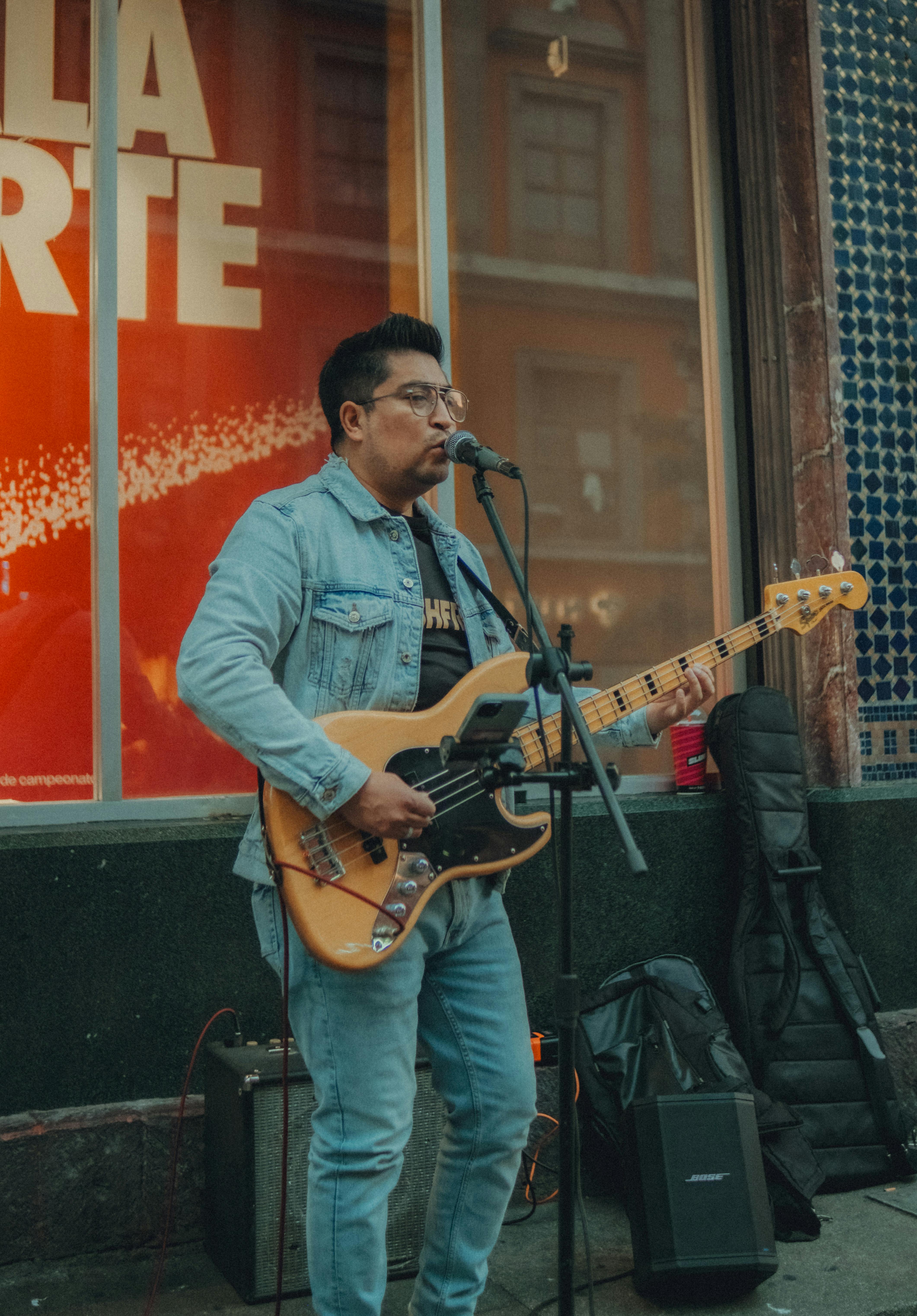 De franc Músic de carrer tocant la guitarra elèctrica i cantant en un entorn urbà. Foto d'estoc