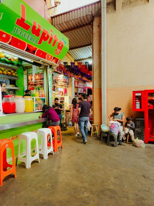 Free Colorful scene of a busy indoor market with a lively juice bar and people milling around. Stock Photo