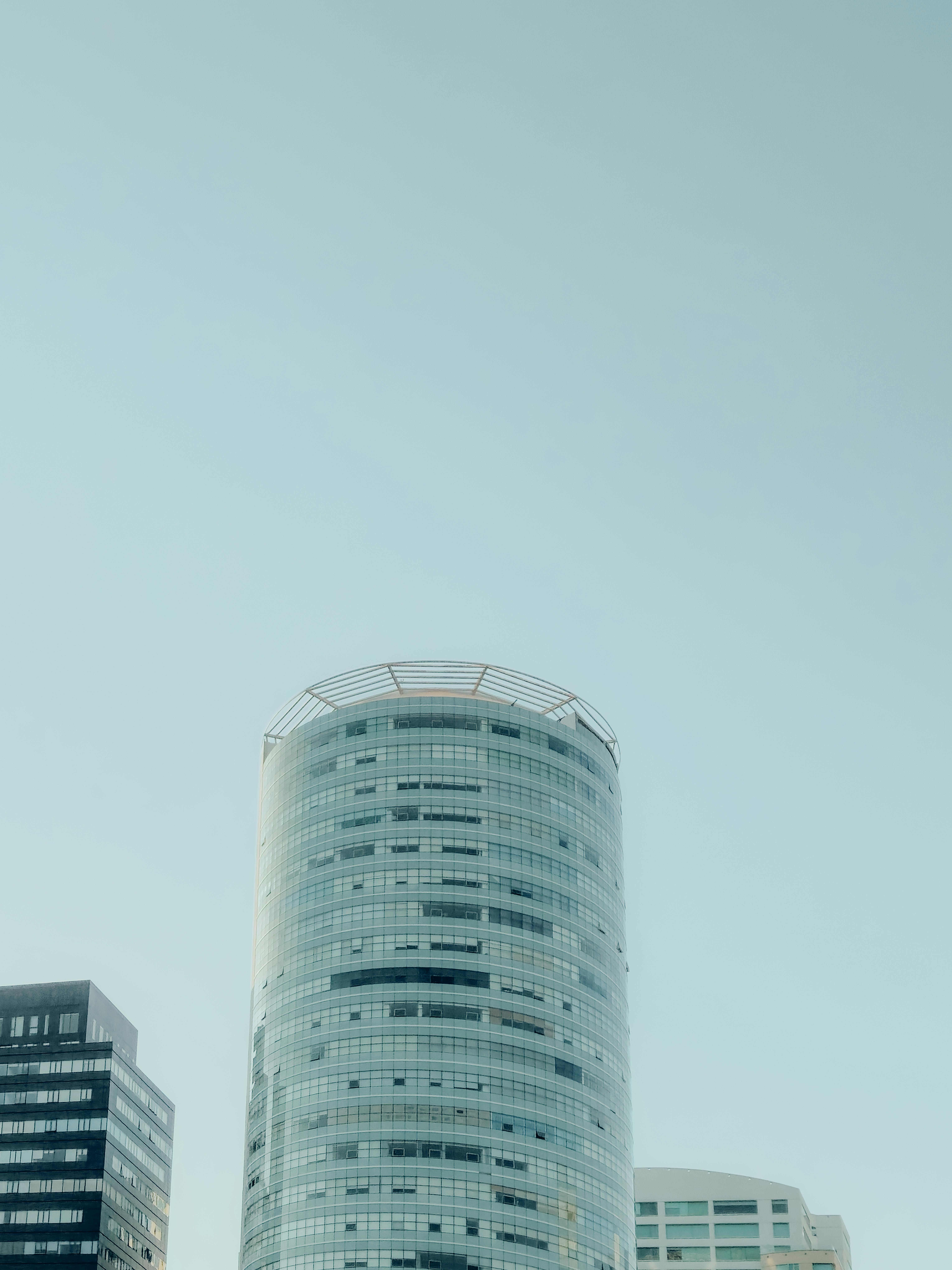 Zadarmo Vysoký moderný sklenený mrakodrap v mestskej panoráme pod jasnou modrou oblohou, minimalistická architektúra. Fotka z fotobanky