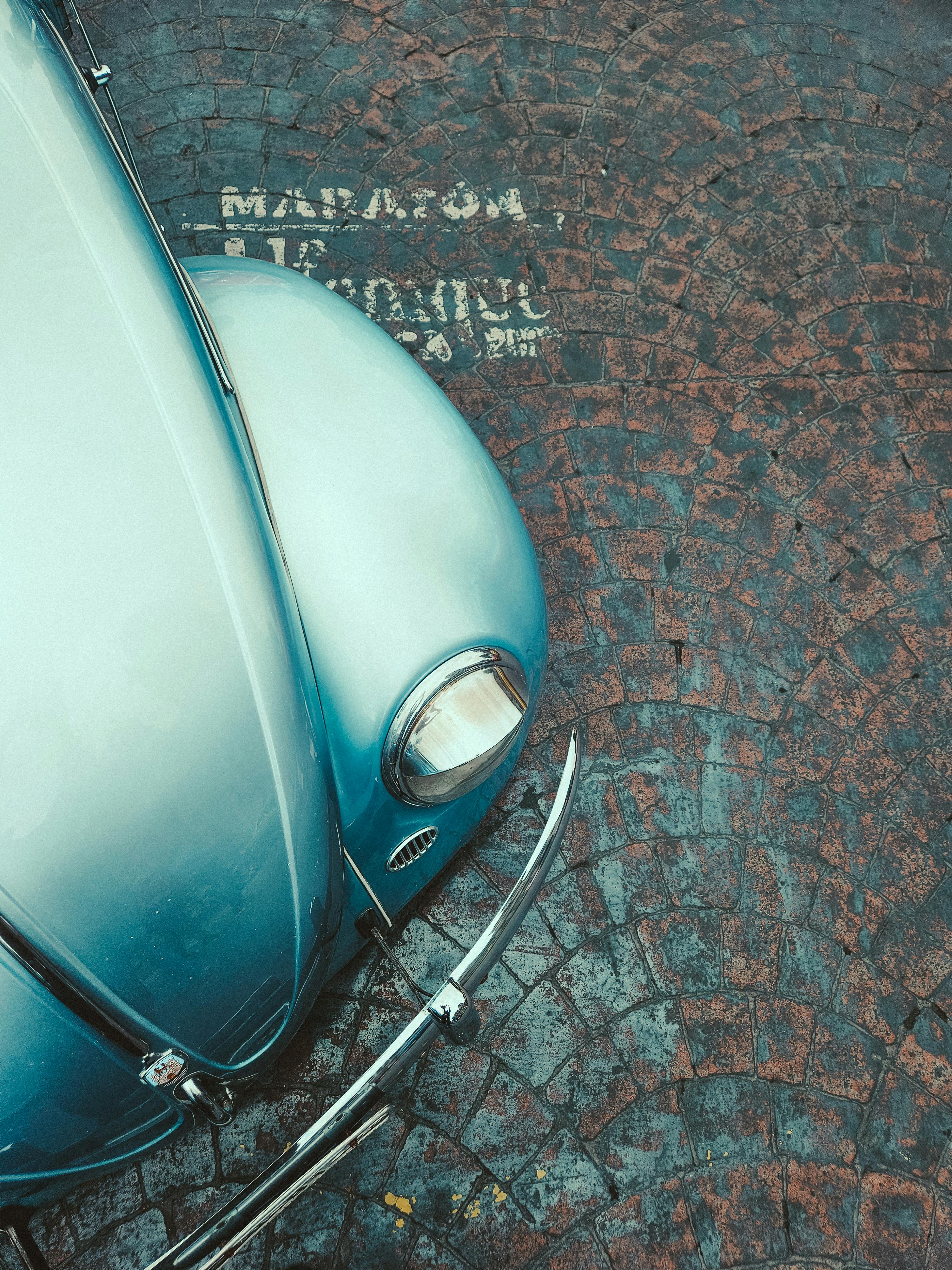 De franc Vista aèria d'un cotxe blau clàssic aparcat en un antic carrer empedrat. Foto d'estoc